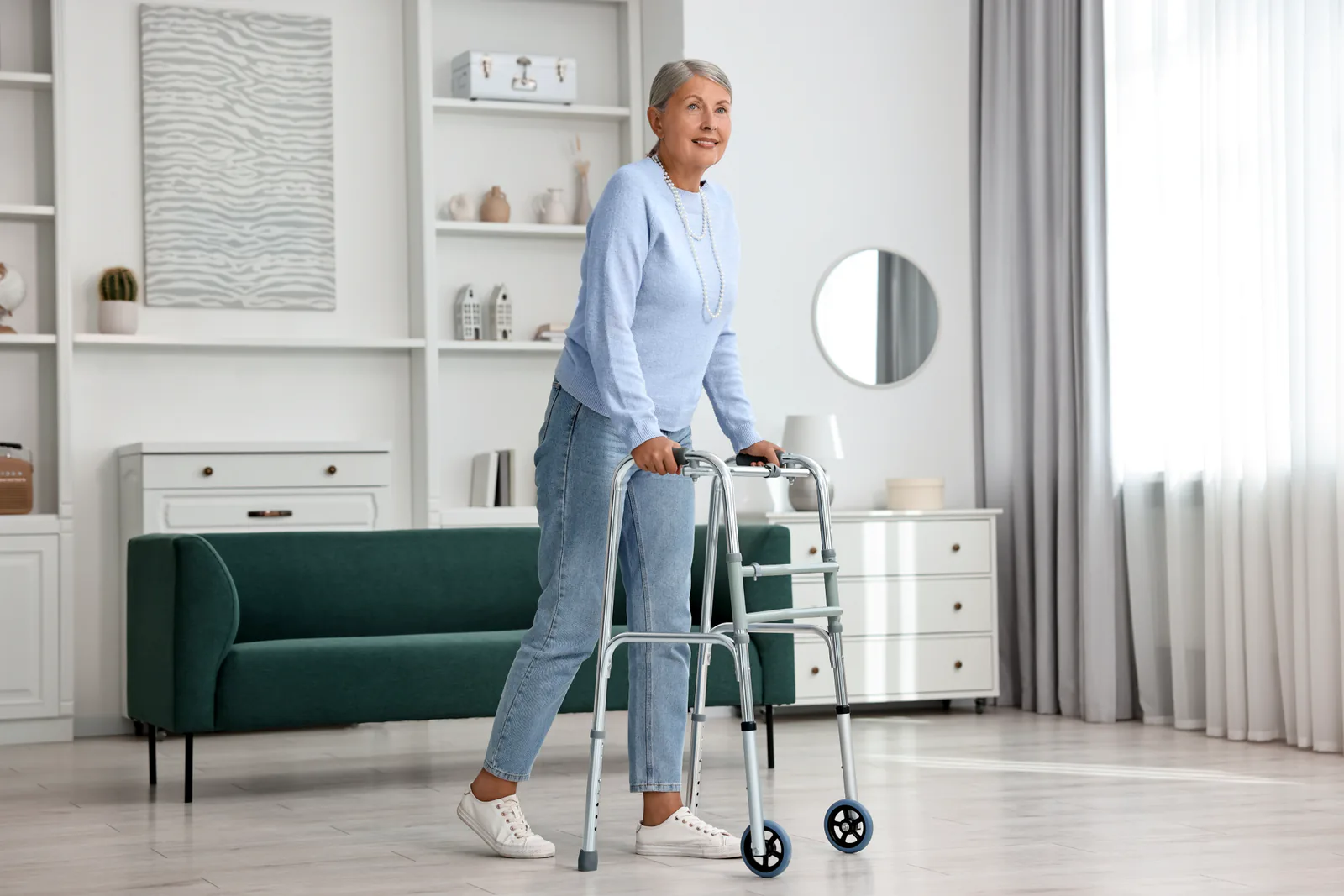 Une femme senior se déplace avec un déambulateur dans un salon lumineux et dégagé